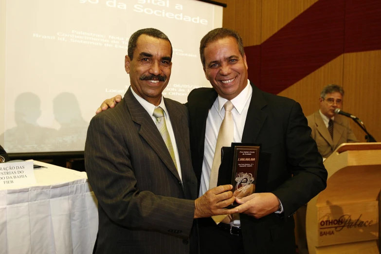 two men standing together and smiling for the camera