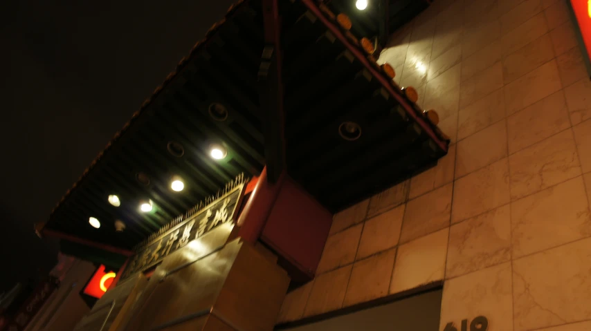 a dark corner with a red clock near some building