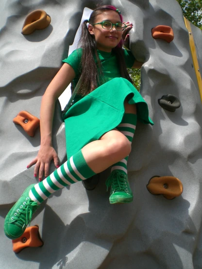 a pretty  sitting on top of a climbing wall