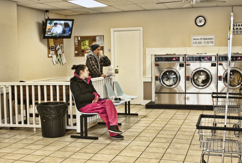 there is a person that is sitting on a chair in a laundry room