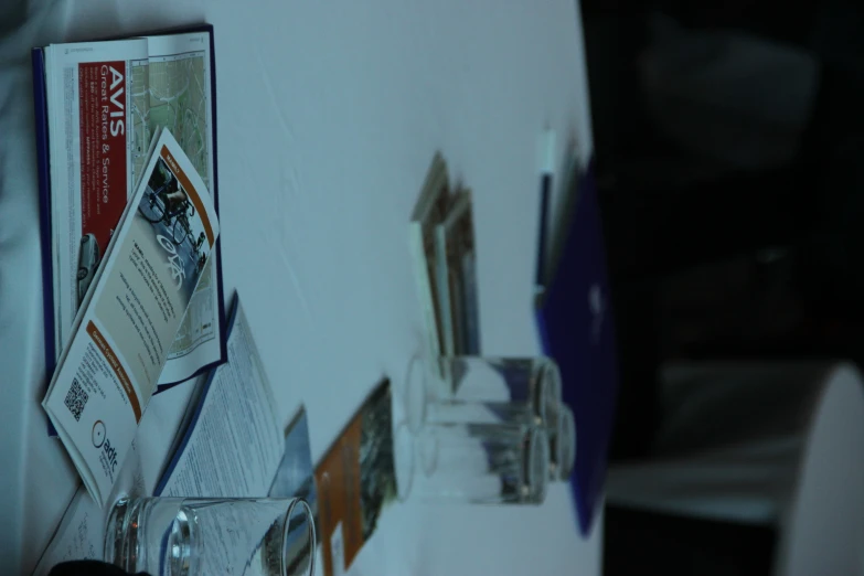 table with glass and papers and pen and glasses on it