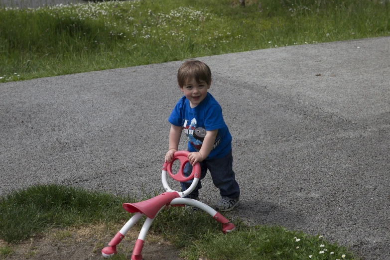 a small boy playing with his yard toys