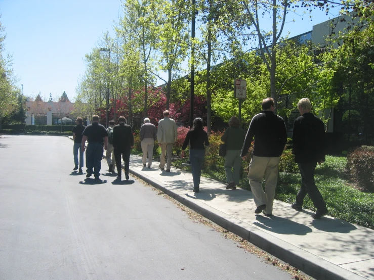 group of people walking down the sidewalk near each other