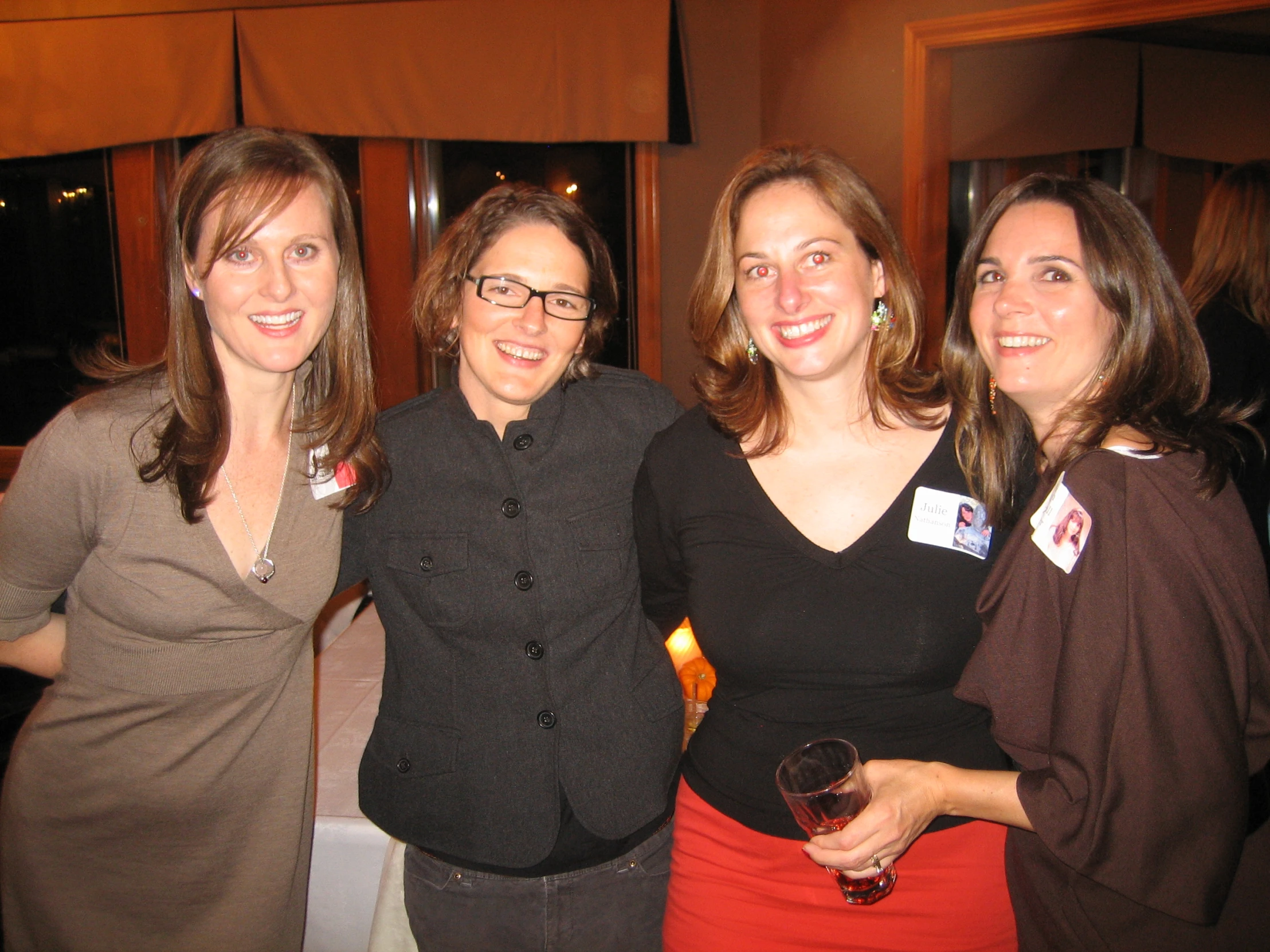 three women standing next to each other posing for a picture