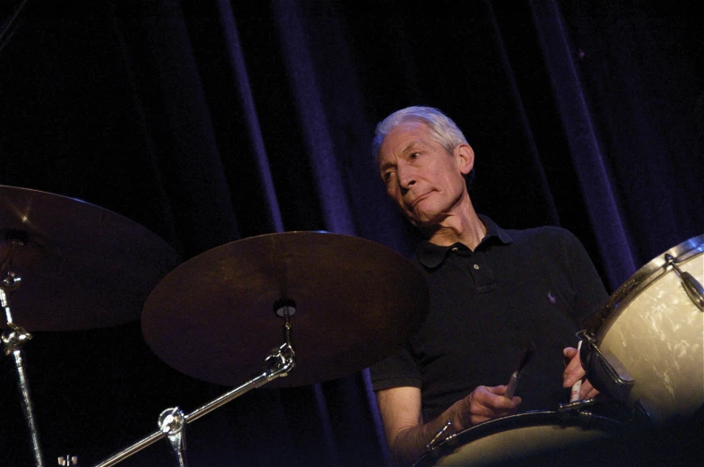 the man is drumming the drums on stage