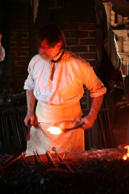 a man with a tie standing by a fire