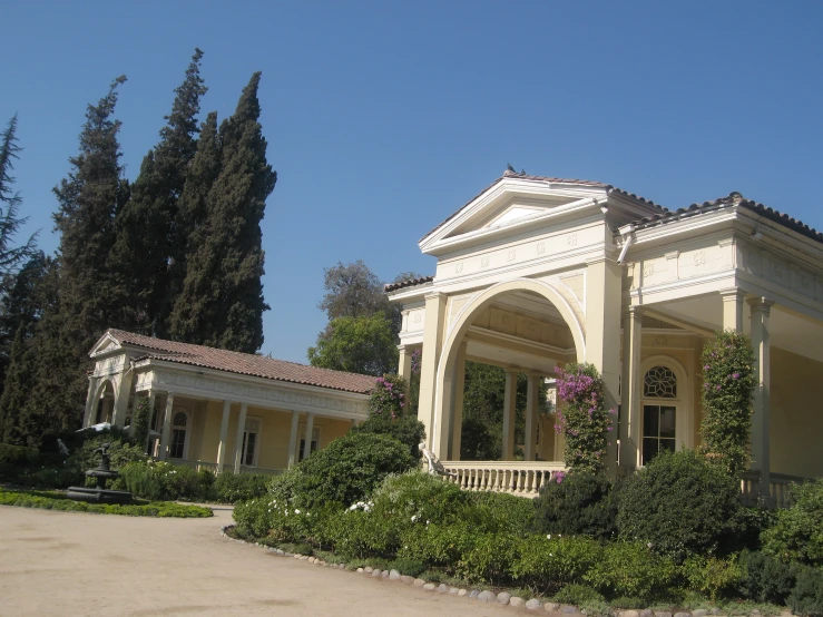 a large house with a courtyard has many shrubs