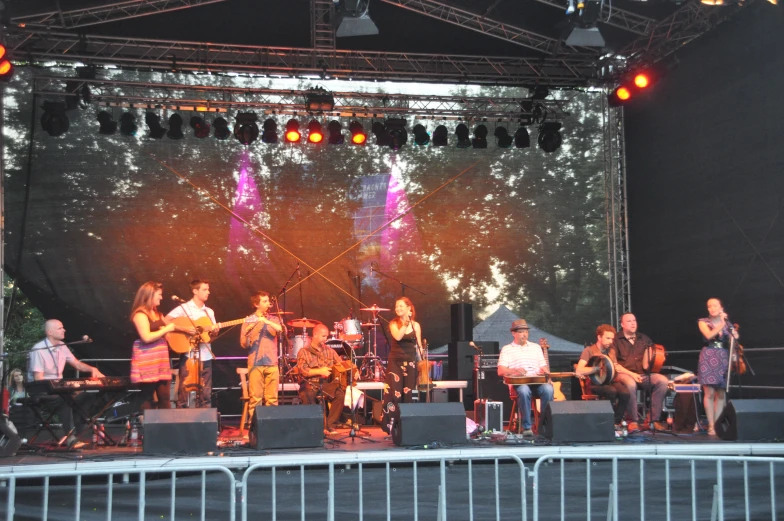 a group of people sitting at a stage performing