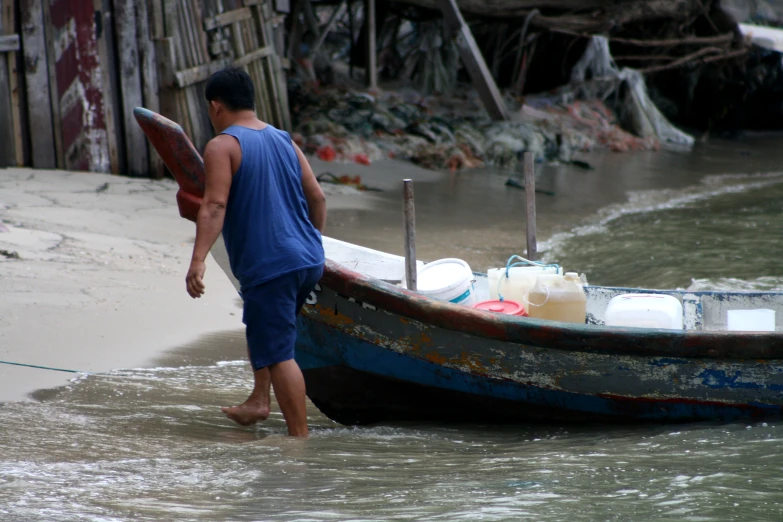 a man is wading out from the water by a boat