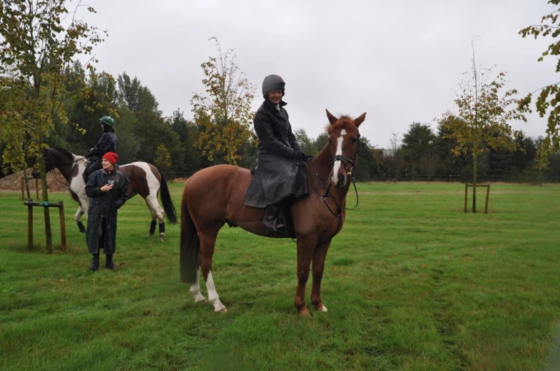 two people ride their horses in the open field