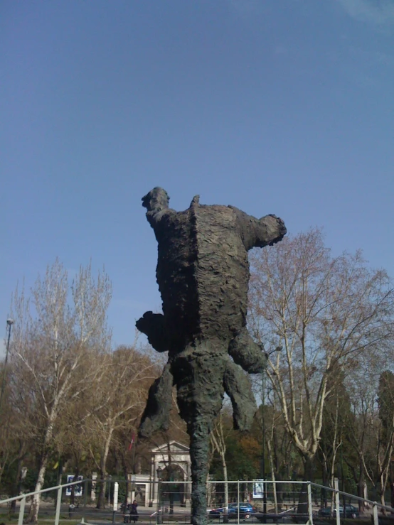 a very large bear statue sitting in the middle of a park