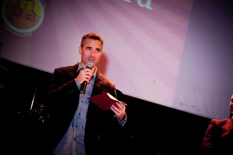 a man giving a speech and smiling at someone