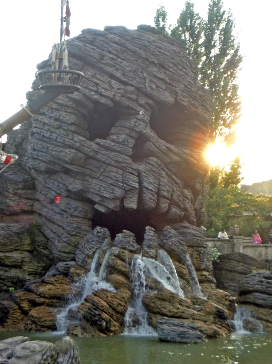 an amut park has a large fountain and huge rock face