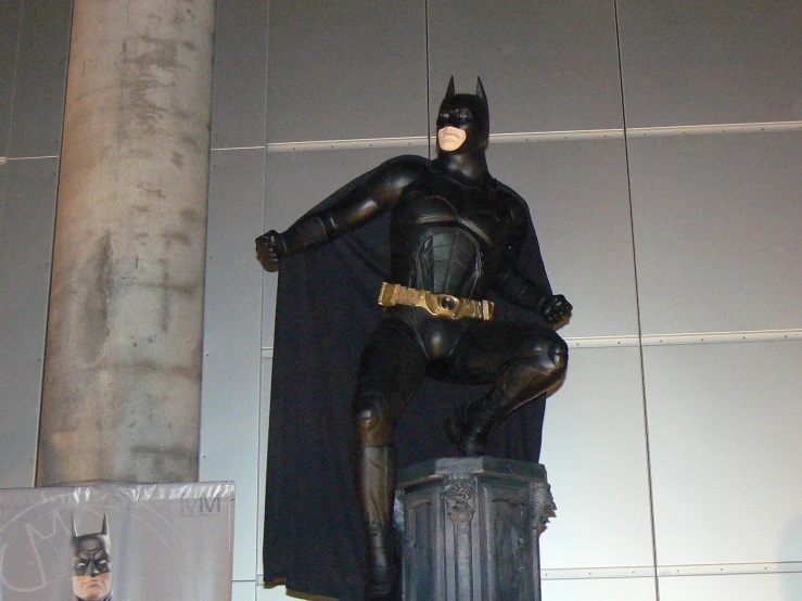 a statue is sitting on top of a garbage can