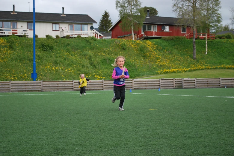 two girls run and play soccer on the grass