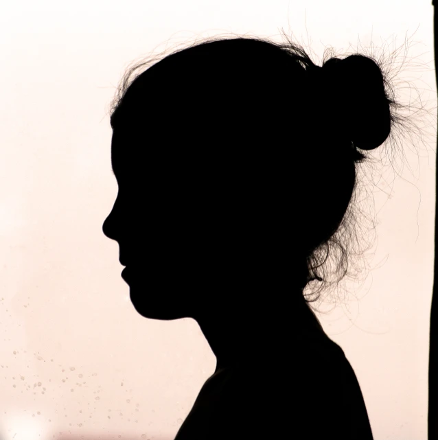 a silhouette of a woman's head and hair is shown