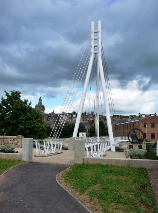 there is a very tall white bridge that is by the park