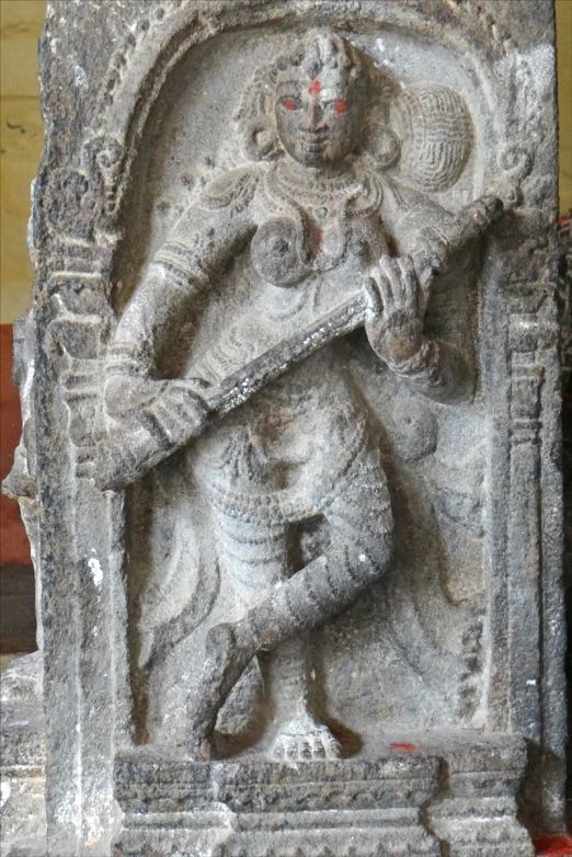 a stone statue depicting a person holding a gun