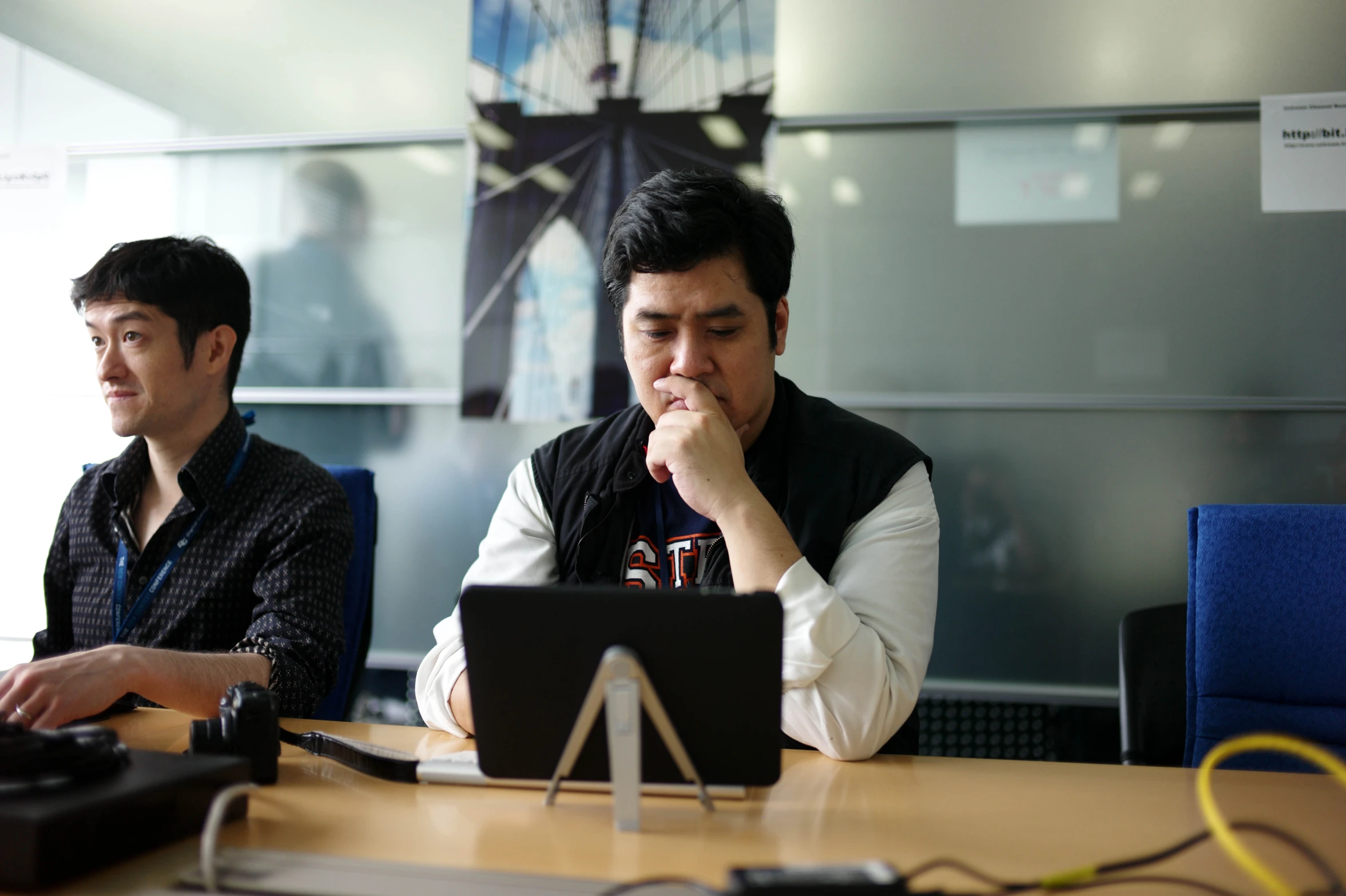 two men are looking at a laptop computer