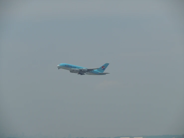 a large blue airplane flying low above water