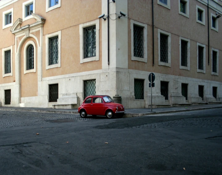 a red car parked in front of a tall building