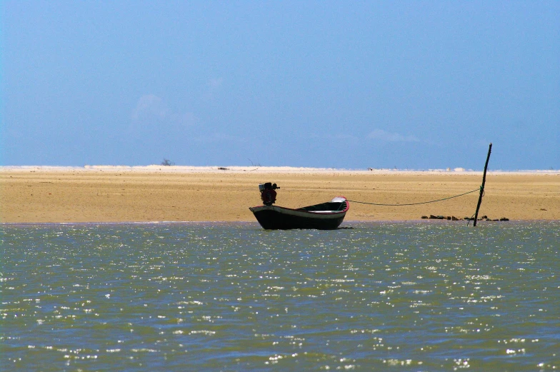 a boat sits in the water near the beach