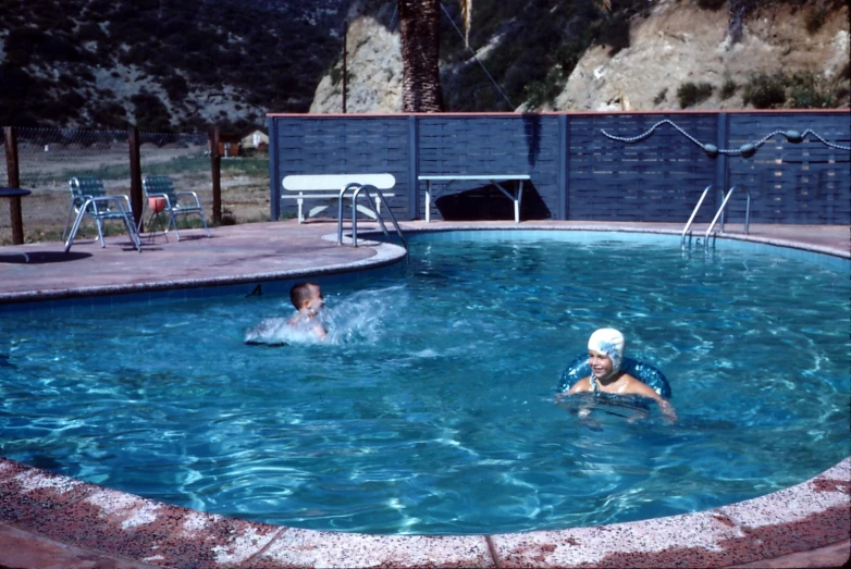 two people in the pool playing with a frisbee