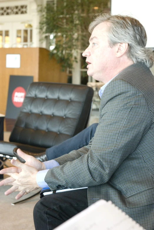 a man sitting on a chair talking to someone