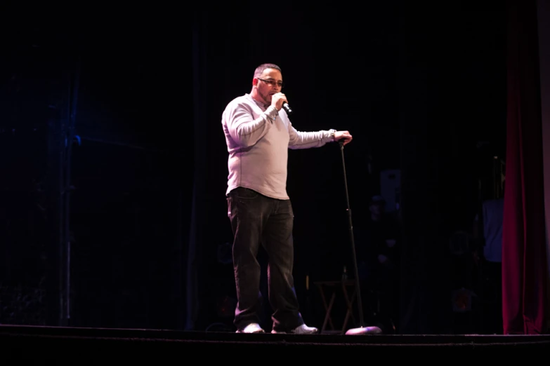 an older man with glasses speaking into a microphone