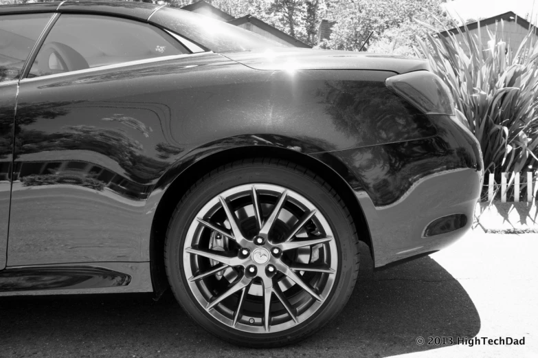 a car with shiny black paint parked by the side of the road