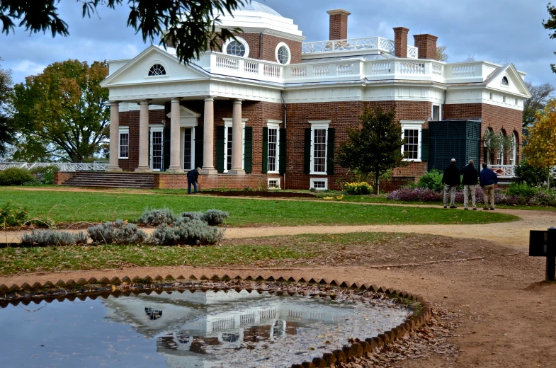 a man stands in front of a large house