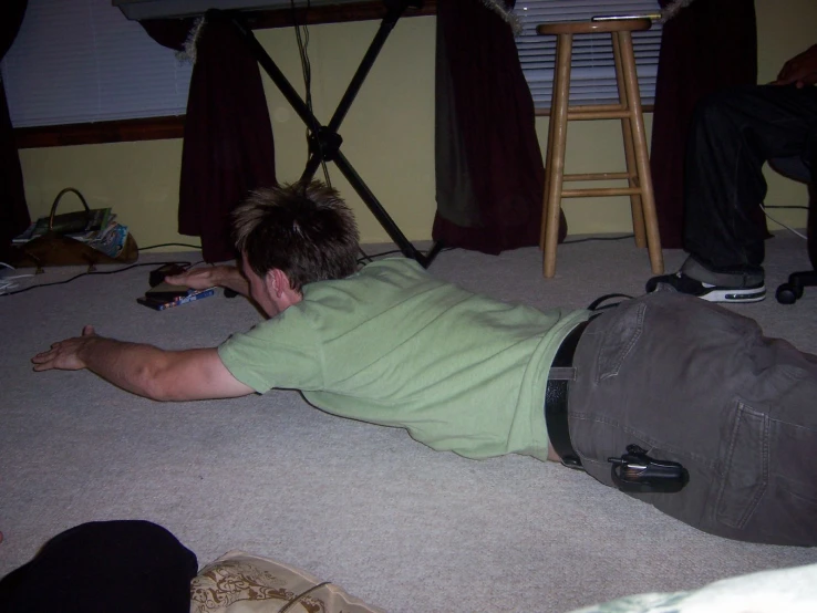 a person laying on the ground playing nintendo wii