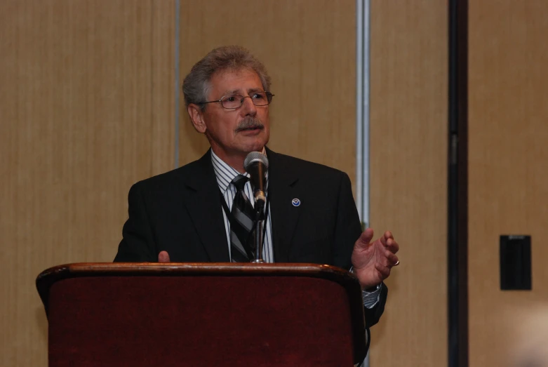 a man standing at a podium giving a speech