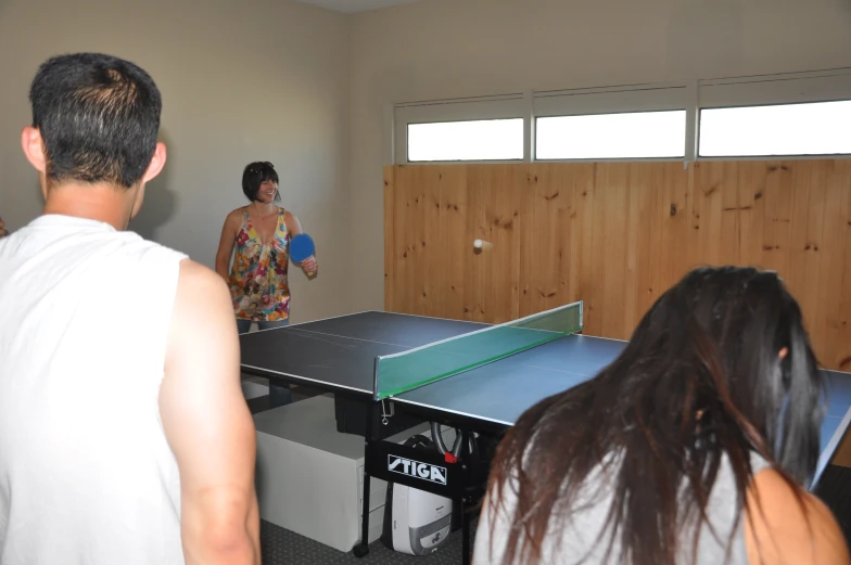 there is a man and woman that are playing ping pong