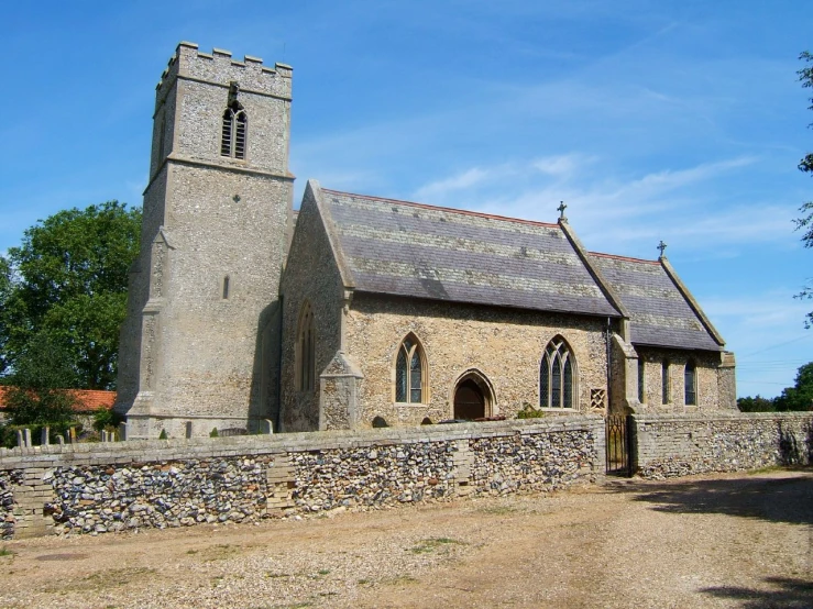 a stone wall and a church in the country side