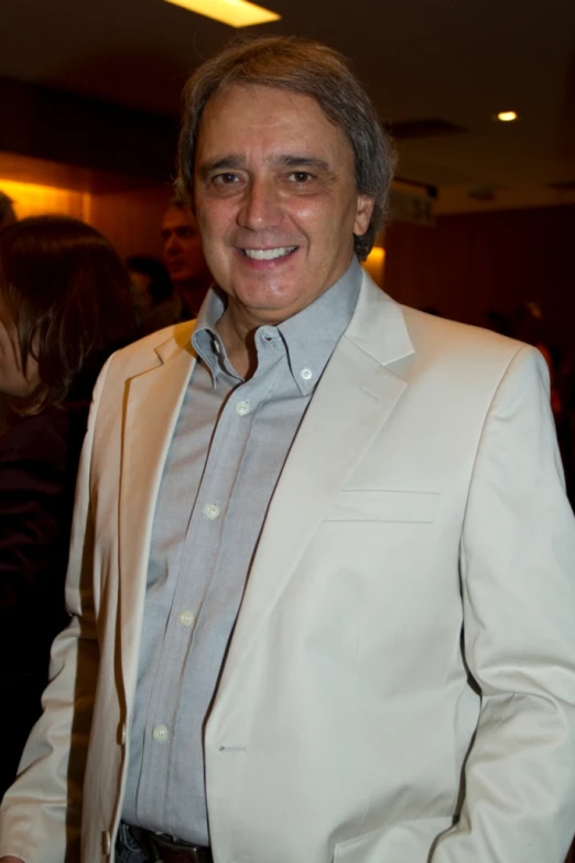 a man with gray hair and wearing a tan suit