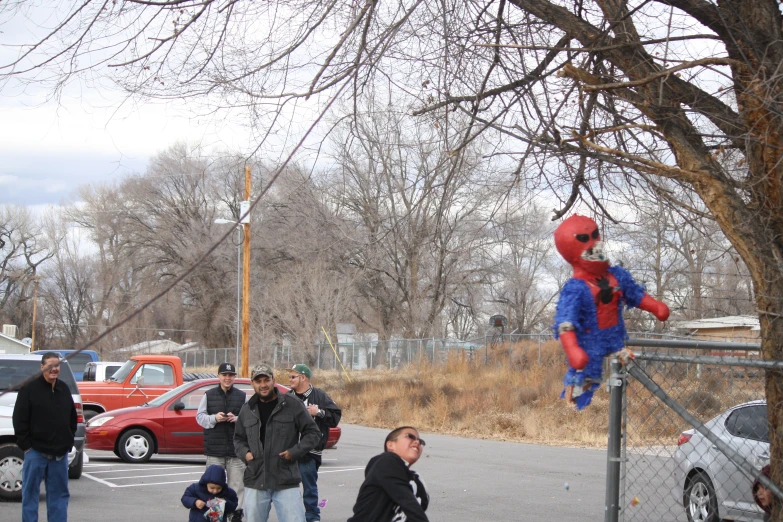 several people walking and a child wearing a spiderman costume