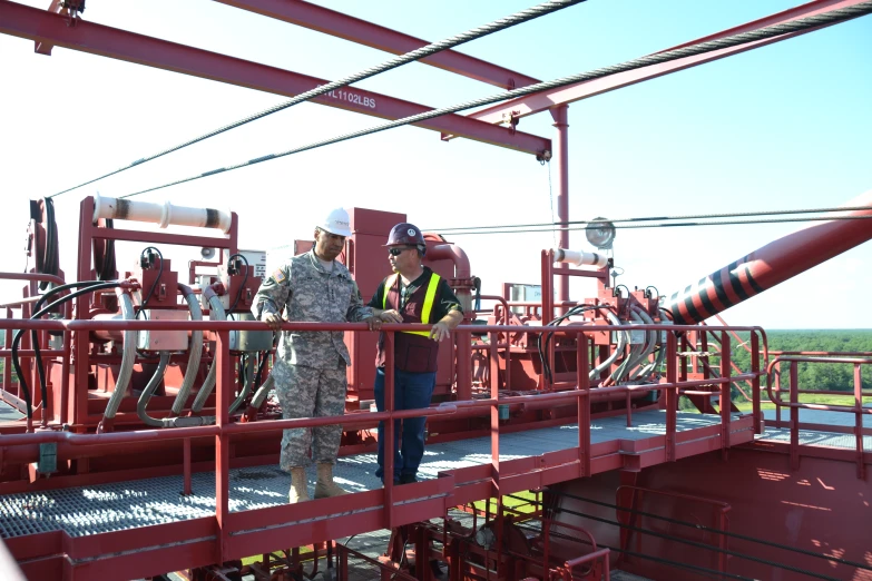 a woman standing on a red bridge between two large pipes