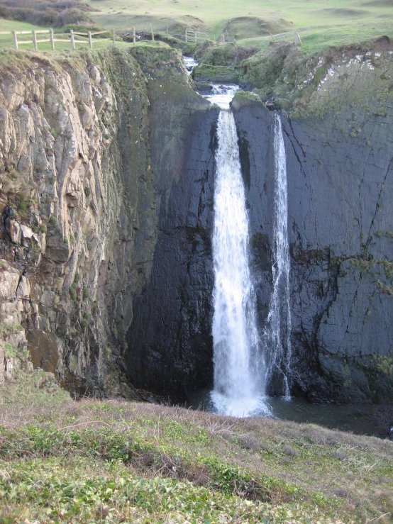 a couple of large waterfalls next to some grass