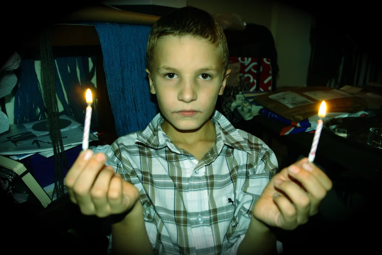 a  holding two candles in his hands