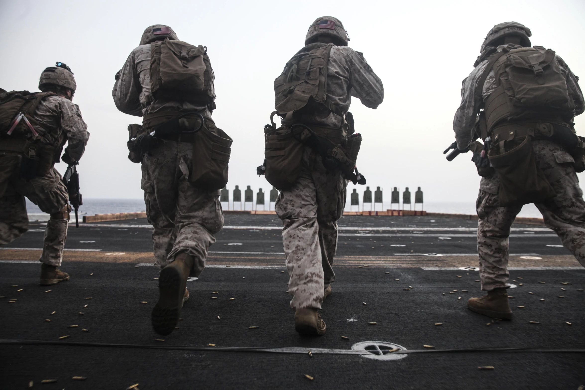 soldiers in fatigues are running on a road