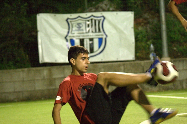 a man with his foot up on the field playing soccer