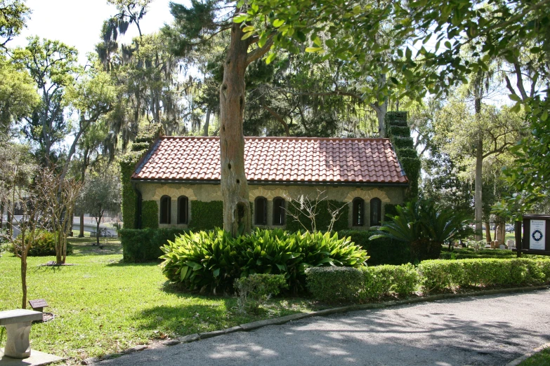 a little house surrounded by trees and grass