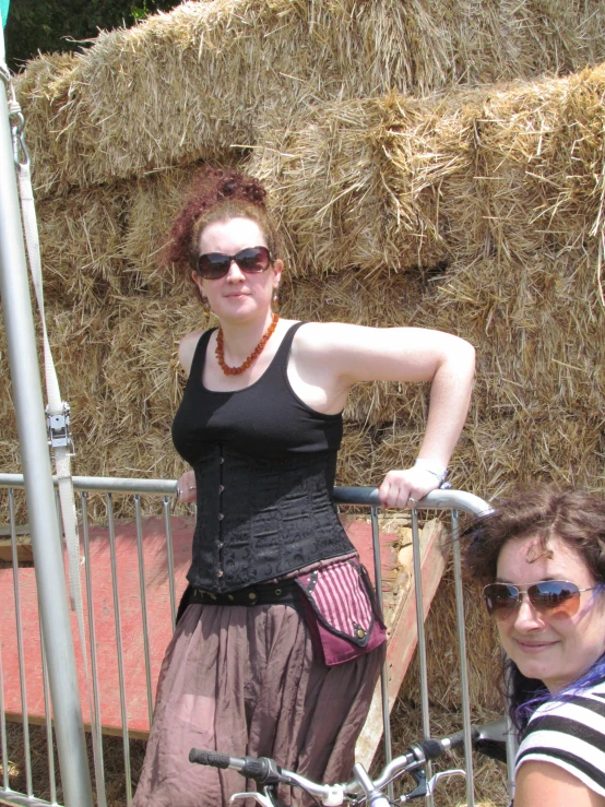 a woman with a skirt, top and purse next to a bicycle