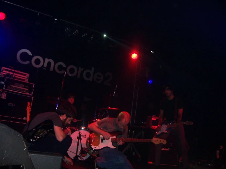 a group of men playing guitars at night