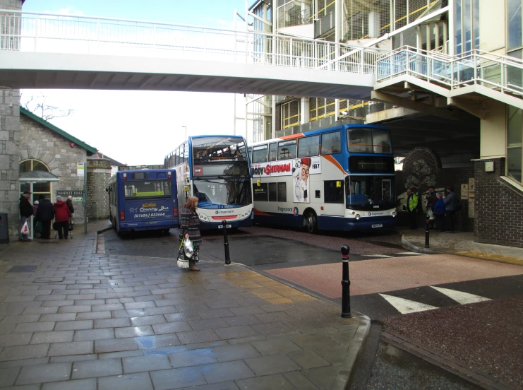 a bus stop and two double decker buses on the street