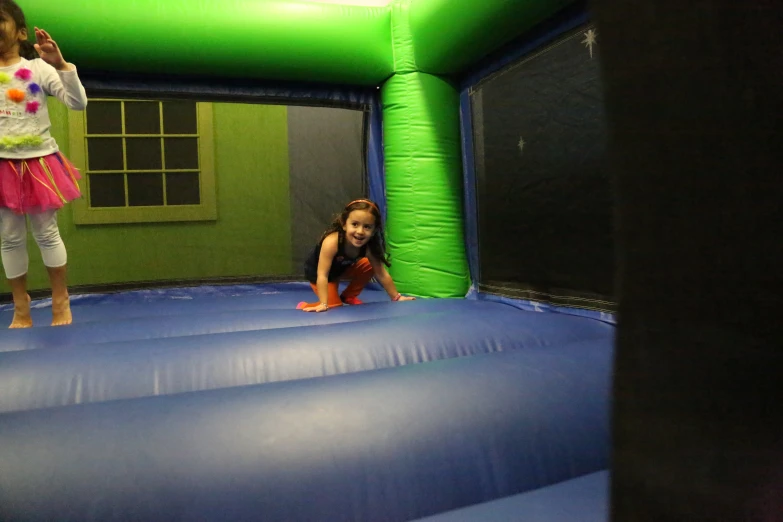 two small children are climbing in an inflatable trampoline