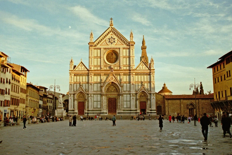 a group of people walking around a tall church