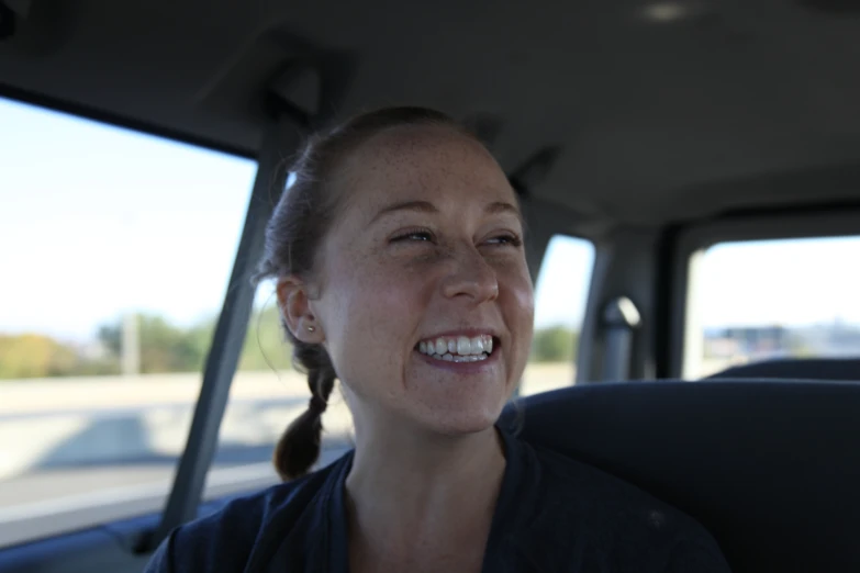 a woman smiling in the back of a vehicle