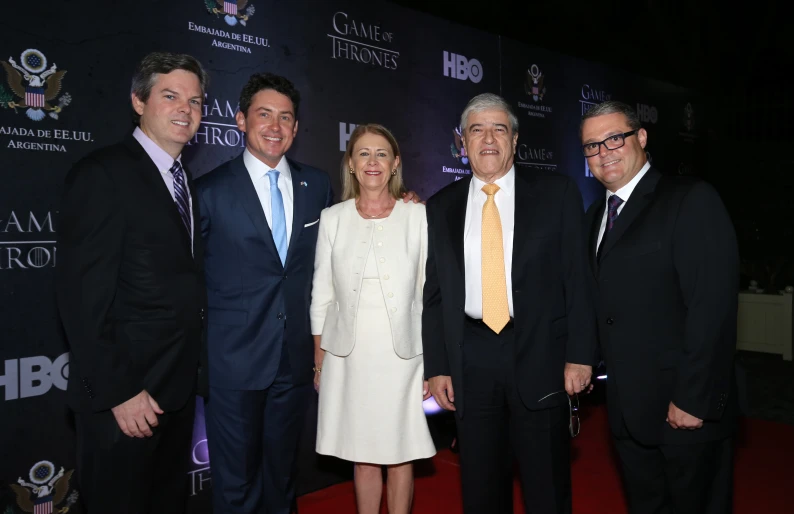 four people are posing for the camera on a red carpet